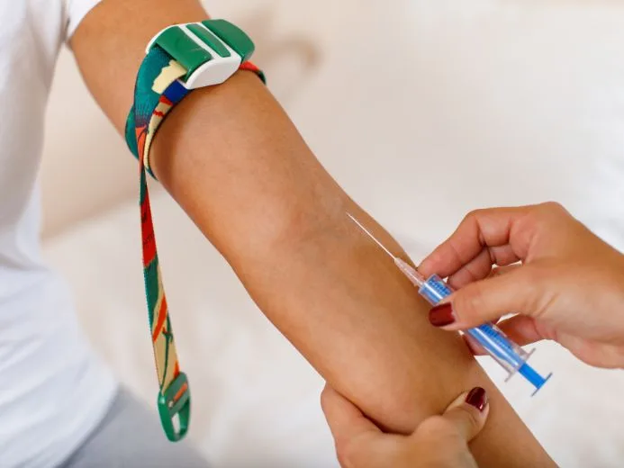 Healthcare professional skillfully prepares for a blood draw with a tourniquet in a clinical setting