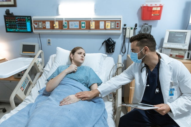 A physician comforting the patient while discussing artificial feeding options