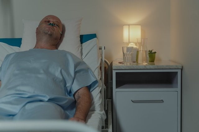 A hospitalized patient receiving breathing assistance 