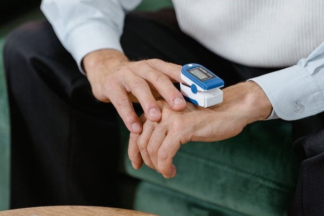 An elderly patient using pulse oximeter at home