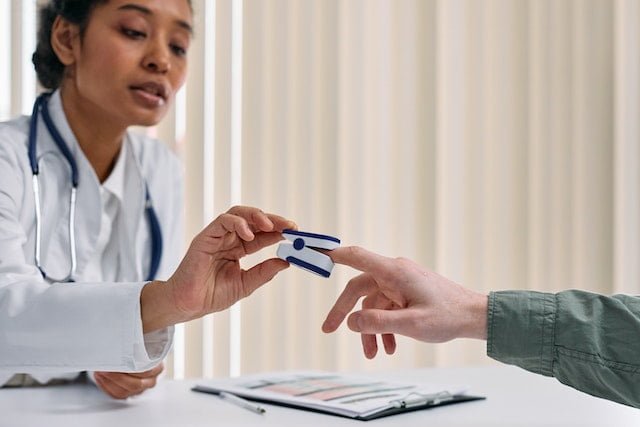 Pulse oximeter being used on a patient by a physician