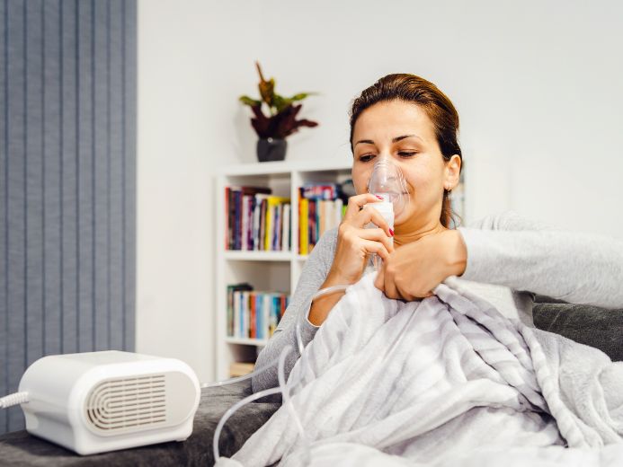 Woman using vapor steam inhaler nebulizer machine