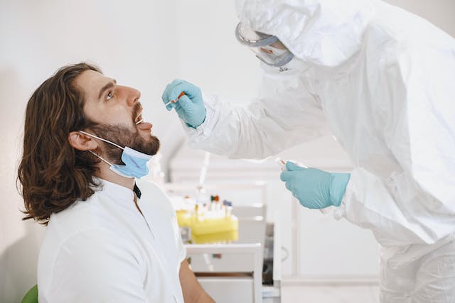 A healthcare professional conducting tracheal swab test on a patient