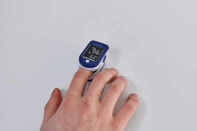 A pulse oximeter attached to a patient’s finger displays oxygen saturation