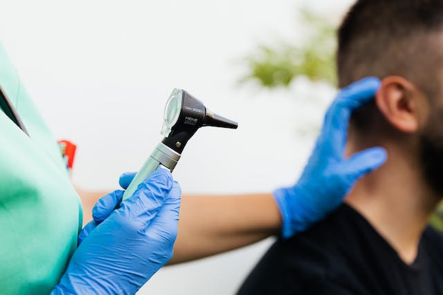 An otoscope being employed on a patient