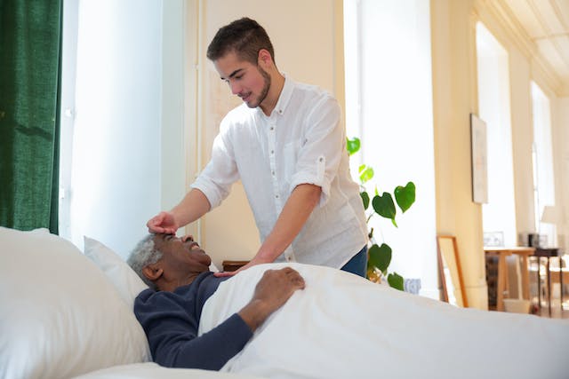 A caregiver with a bedridden elderly patient