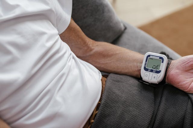 A digital blood pressure monitor is being used in a home setting
