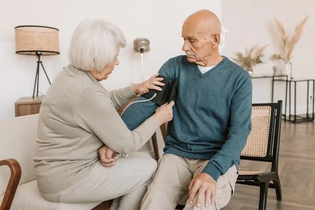 Upper arm blood pressure measurement device being used in a home setting