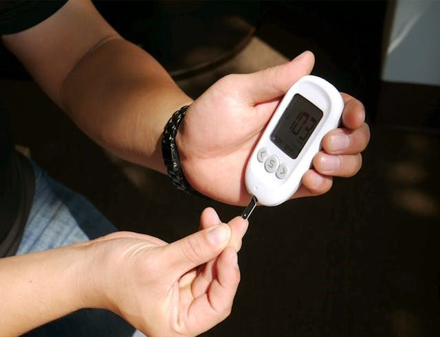 A control solution test strip is being used with a glucometer for BGL measurement