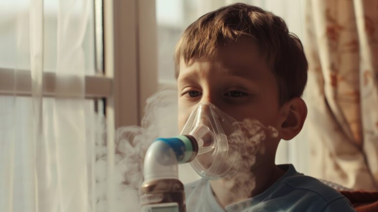 Young child wearing a Venturi mask for oxygen therapy, with visible mist from the nebulizer