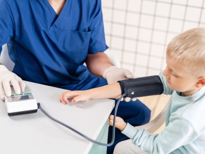 A child being is examined using a pediatric blood pressure monitor