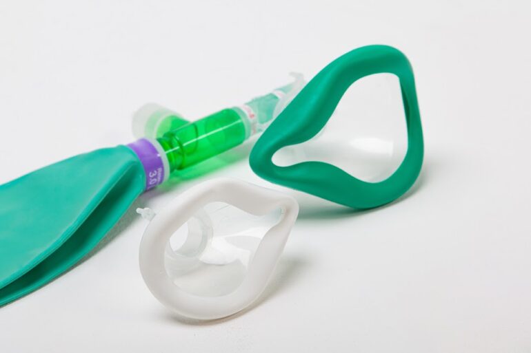 Close-up view of green and white Venturi masks with an attached oxygen tube