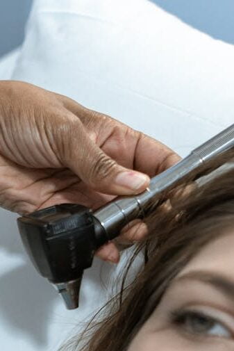 An ear thermometer is being employed to take a child’s temperature An ear thermometer is being employed to take a child’s temperature