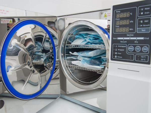 A manual autoclave sterilizer is being used for cleaning medical instruments