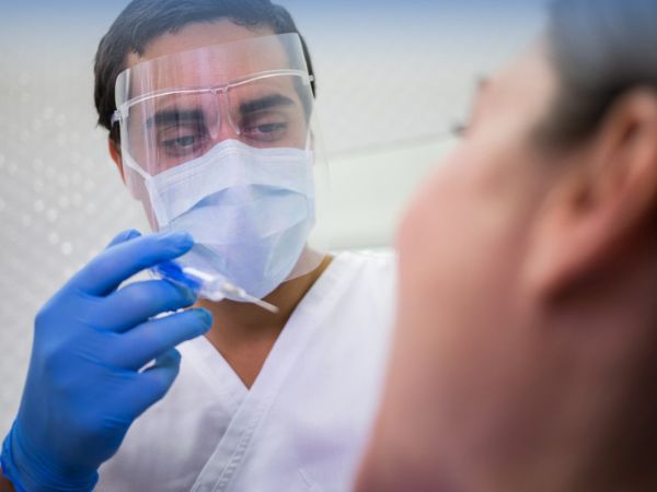 Wearing a medical face shield during patient examination prevents the doctor from getting infected